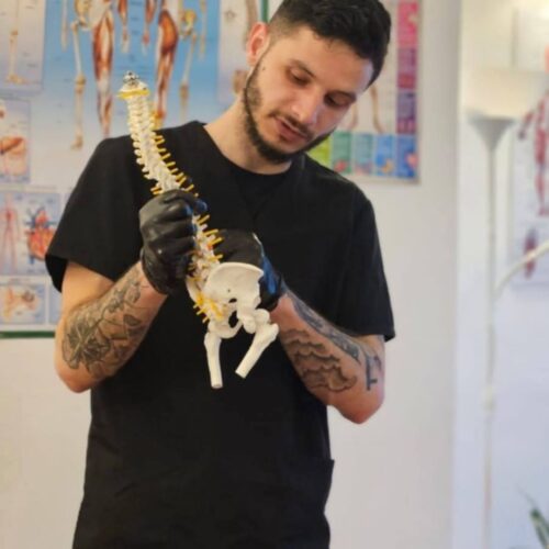 Un maseur profesionist (Mihai Sofron) efectuând o ședință de masaj terapeutic, simbolizând tratamente pentru dureri de spate, hernie de disc și alte afecțiuni musculo-scheletale în Londra.